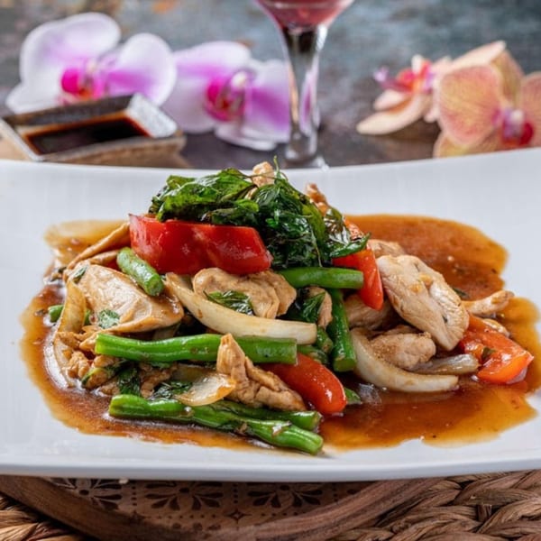 Thai chicken stir-fry with green beans, red peppers, onions, and basil in a savory sauce.